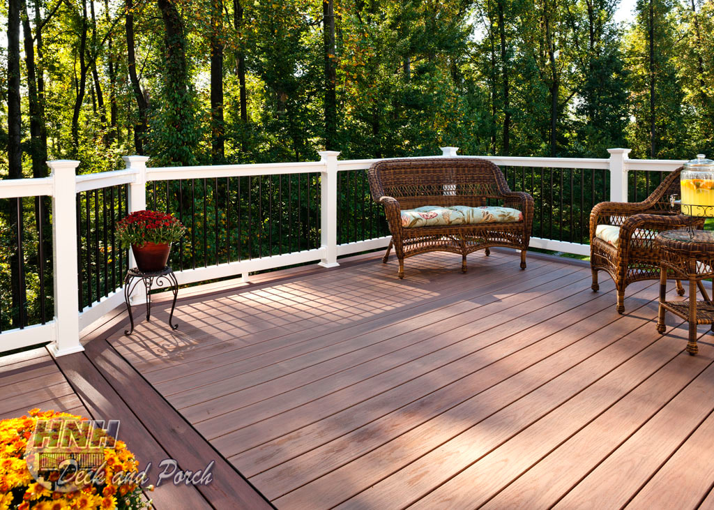 Wolf Tropical Hardwoods Collection PVC Decking with Amberwood flooring and Deckorator's white vinyl railing with black round aluminum balusters.