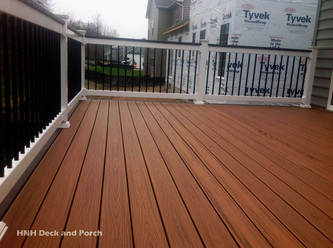 Composite deck using Trex Transcend Tiki Torch flooring and Spiced Rum border and cap rail.