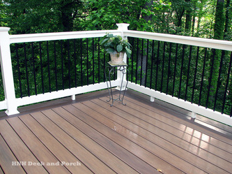 Wolf Home Products Vinyl deck using Longevity black aluminum balusters with white vinyl railing.