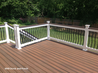 Composite deck by Trex Transcend decking with black brogue aluminum balusters with white PVC railing and Vintage Lantern cap rail.