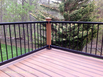 Composite deck using black aluminum railing and balusters with Trex Transcend Tree House posts and i-lighting post caps.